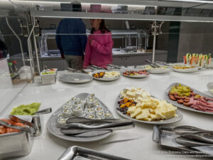 a buffet table with plates of food and a woman standing behind