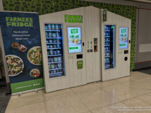a vending machine with a sign and a green wall