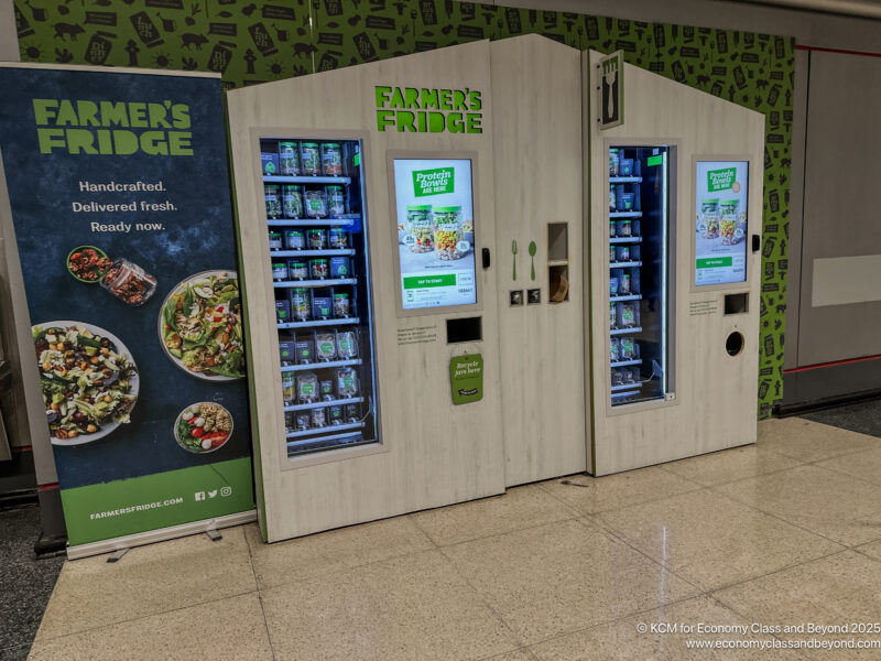 a vending machine with a sign and a green wall