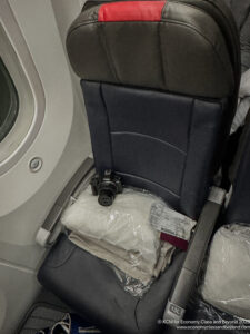 a seat with a camera and a bag on it