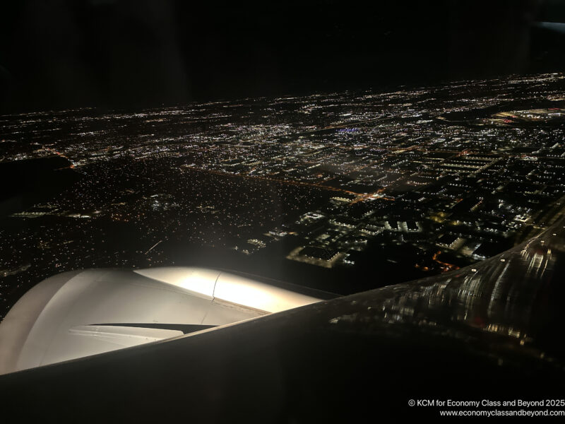 an airplane wing and a city at night