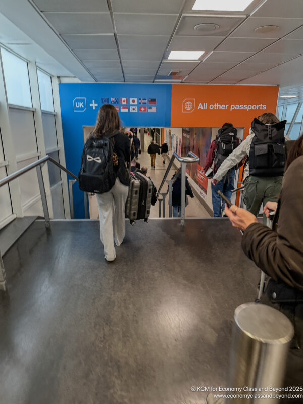 people walking down a walkway with luggage