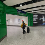 a woman walking with luggage in a airport