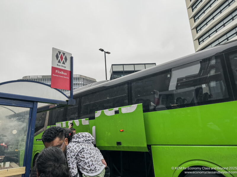 people standing next to a bus
