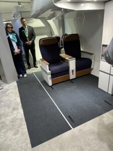 a group of people standing in a room with two seats