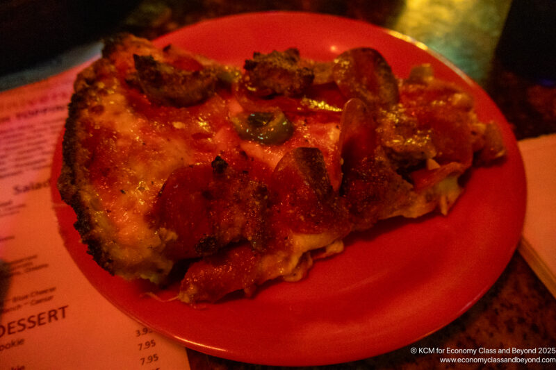 a slice of pizza on a red plate