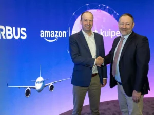 two men shaking hands in front of a large screen with an airplane