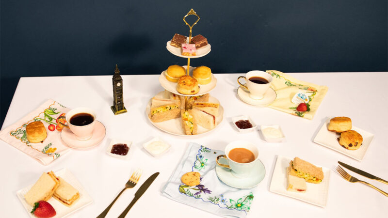 a table with a tray of food and cups of coffee