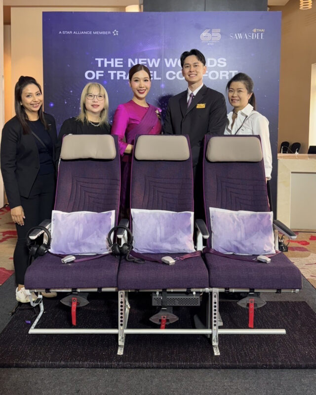 a group of people standing next to a row of chairs