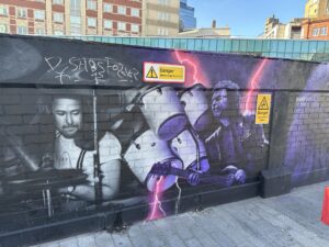 a mural of a group of musicians on a brick wall