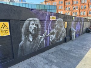 a wall with a mural of a man smoking a cigar