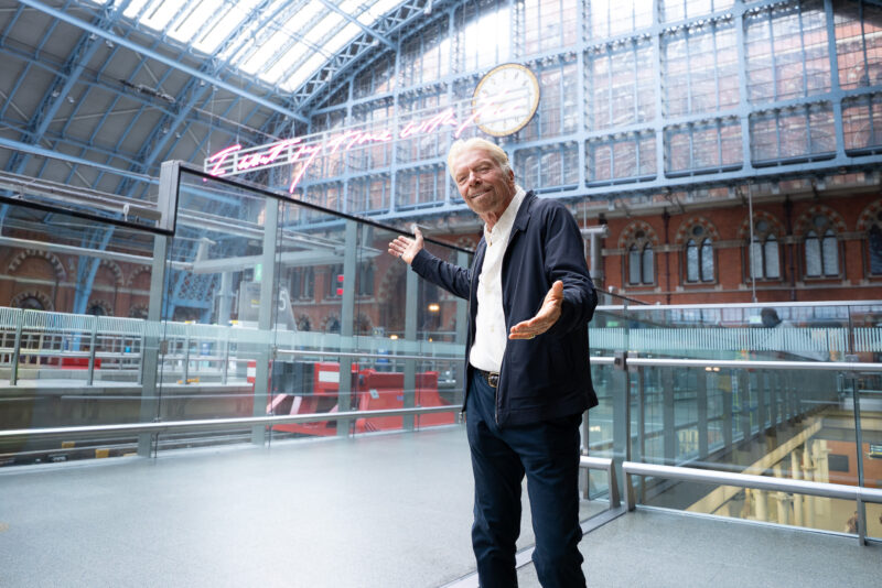 a man standing in a building with a clock
