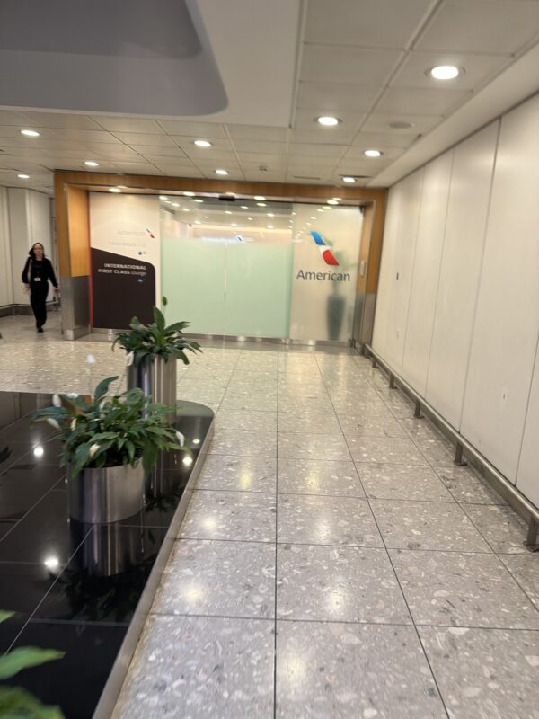a hallway with a sign and plants