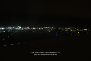 a city at night with lights on the water