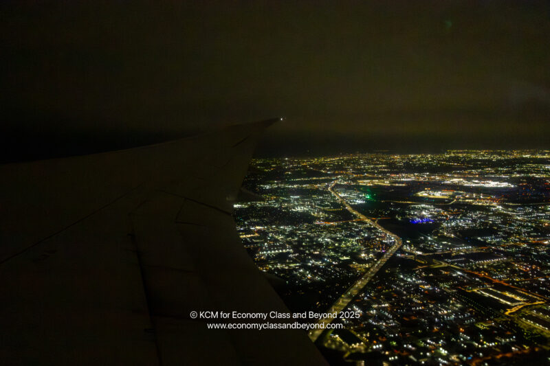an airplane wing and city lights at night
