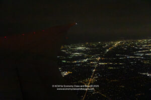 an airplane wing with lights in the background