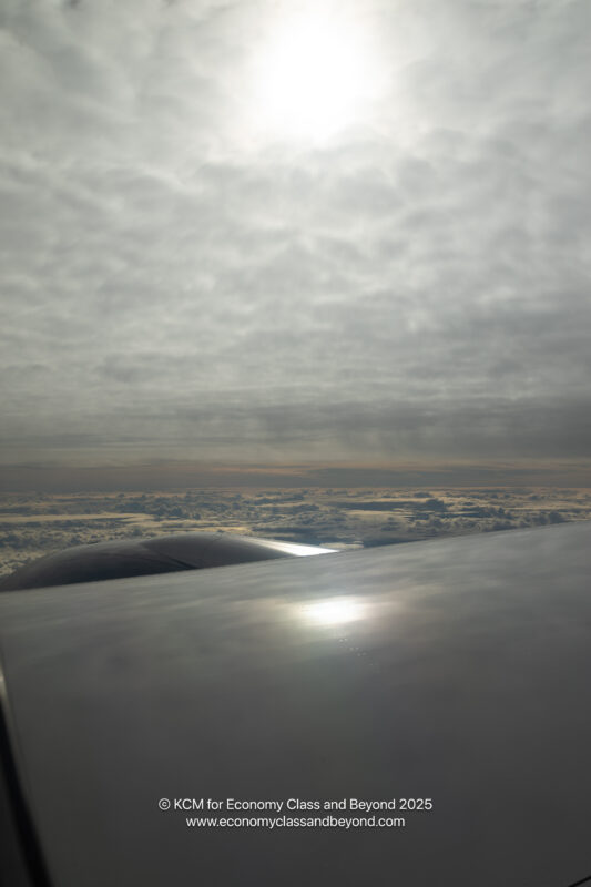 a view of clouds and a plane wing