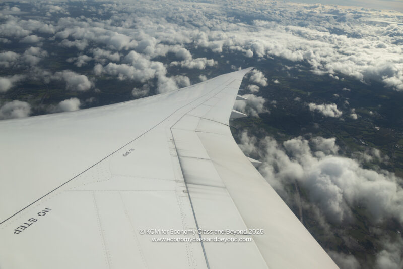 an wing of an airplane above clouds