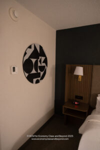 a room with a bed and a wall art