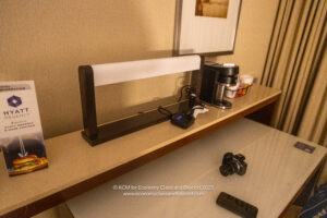 a table with a lamp and coffee maker and a camera
