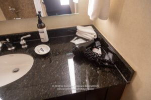 a bathroom sink with a blow dryer and a towel on the counter