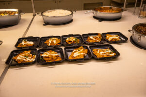 a group of black rectangular trays with food on it