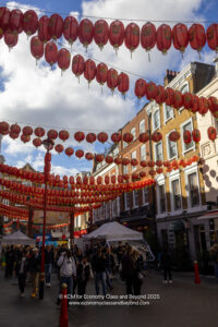 a street with red lanterns and people walking around