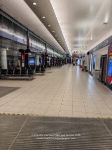 a large airport terminal with benches and signs