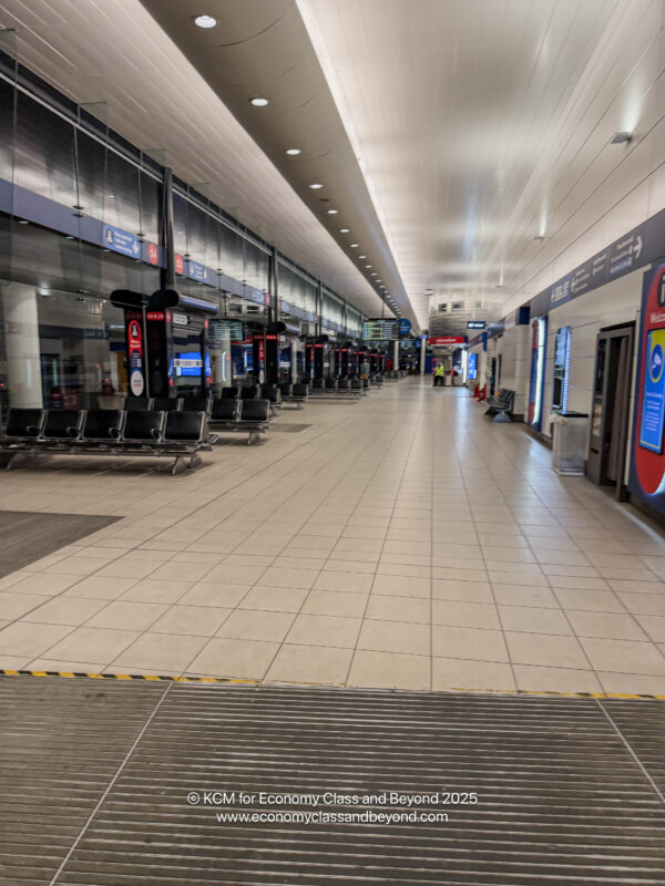 a large airport terminal with benches and signs