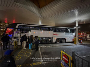 a group of people standing next to a bus