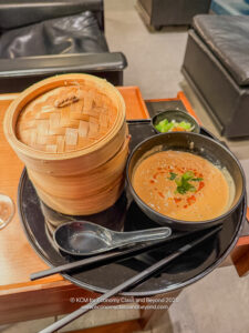 a bowl of soup and a stack of food on a black plate