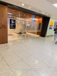 a woman walking in a hallway with a glass door