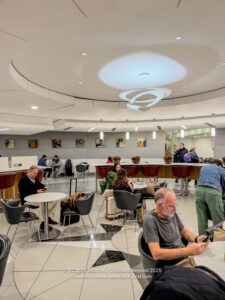 people sitting in a room with tables and chairs