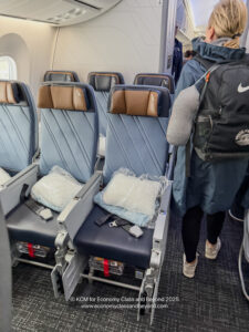 a person walking in an airplane with chairs