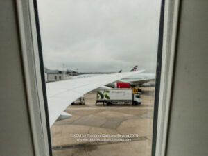 a window with a view of planes and trucks