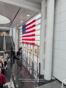people standing in a hallway with a flag on the wall