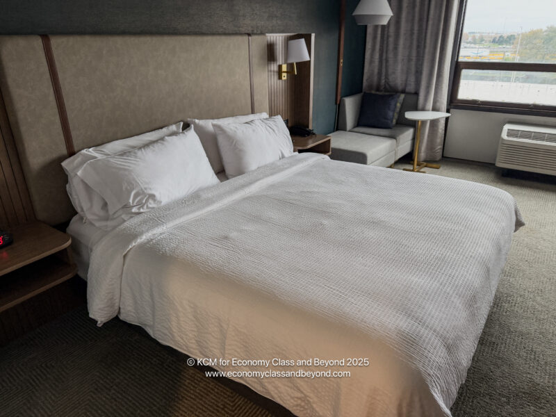 a bed with pillows and a couch in a hotel room