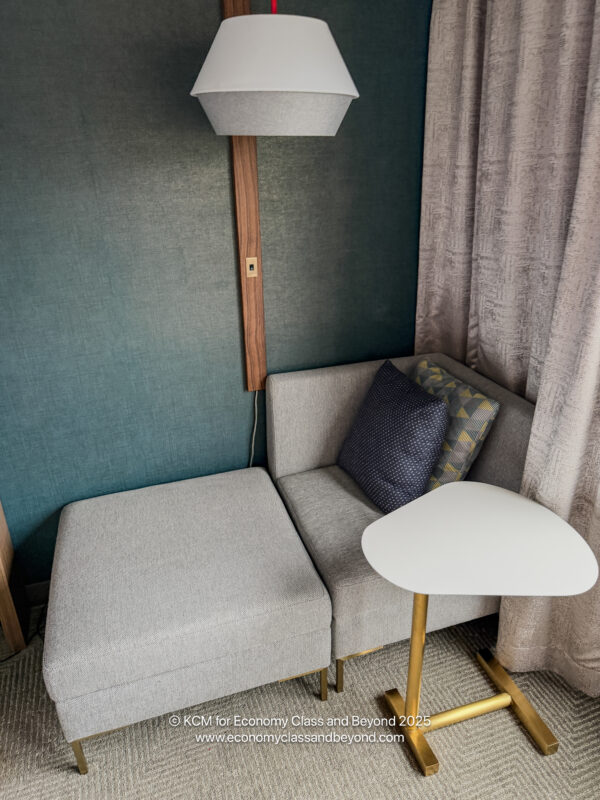 a corner of a room with a couch and a lamp