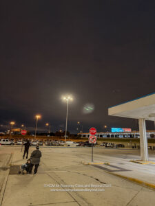 a gas station with people walking in front of it