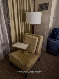 a chair with a table and a lamp in a room