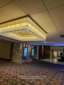 a room with a large chandelier and a television