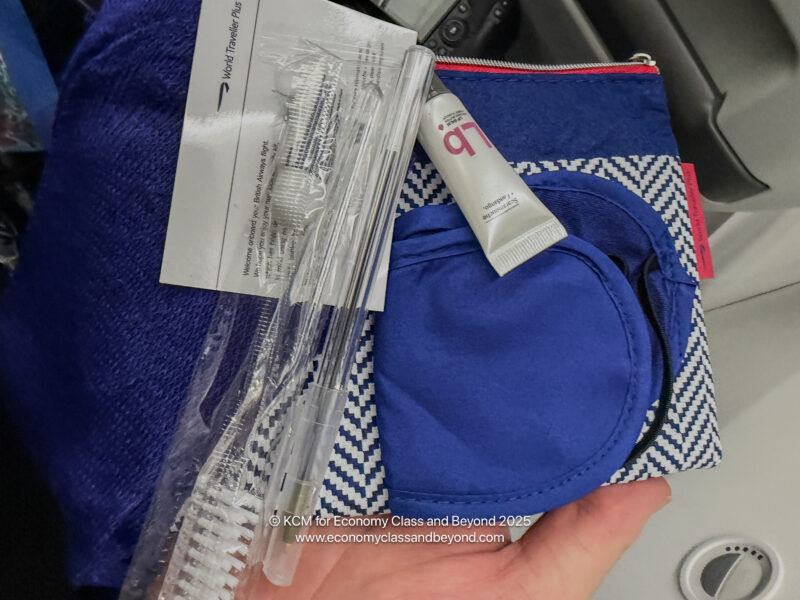 a hand holding a blue towel and toothbrushes