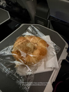 a croissant in a plastic bag on a tray