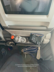a camera and a bottle on a shelf in a plane