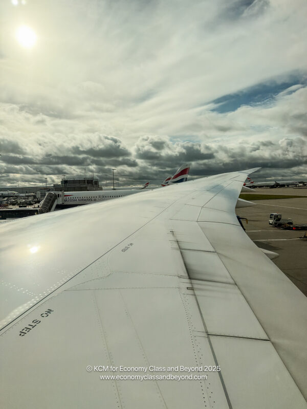 an airplane wing with clouds in the sky