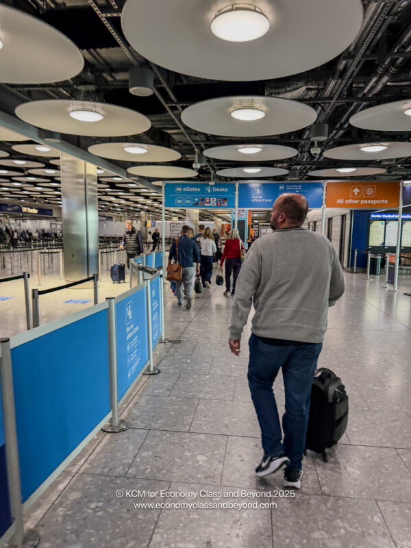a man walking with luggage in an airport