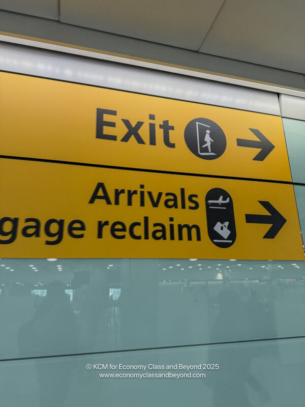 a yellow sign with black text and arrow