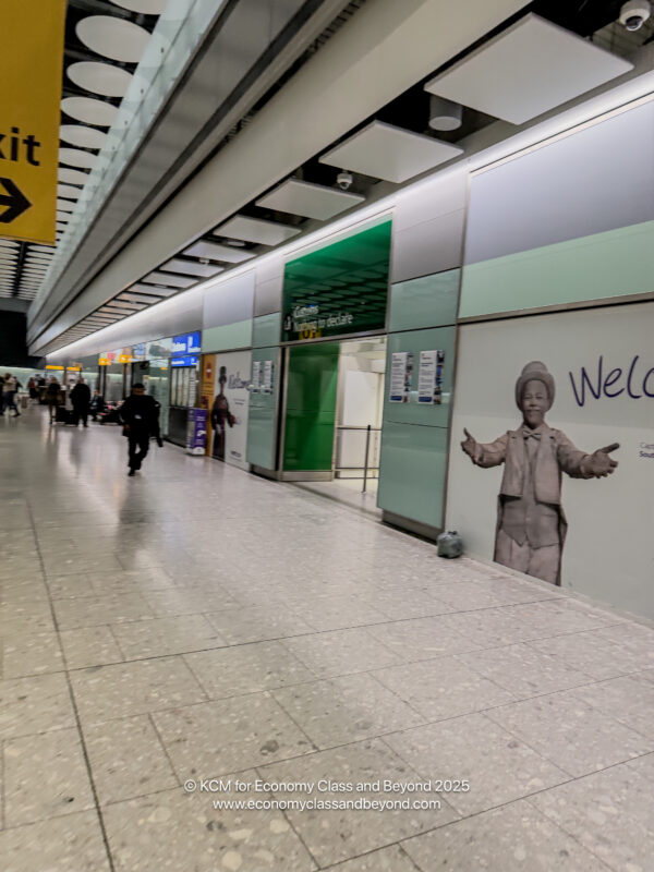 a hallway with people walking and a mural on the wall