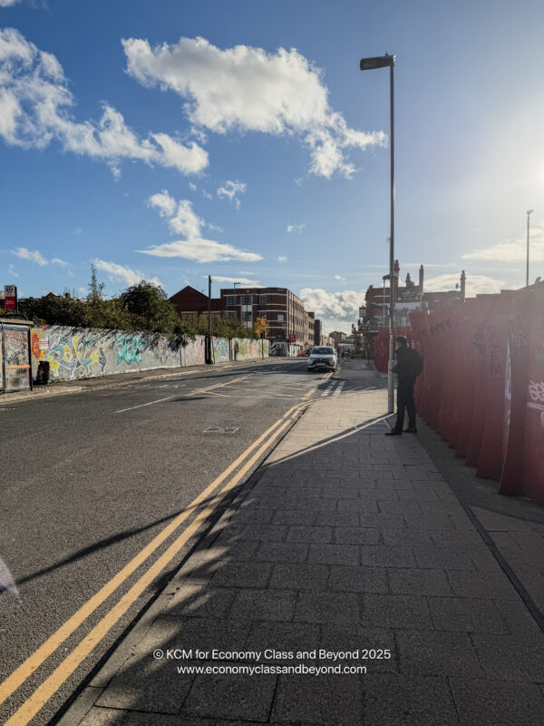a street with a person standing on a sidewalk