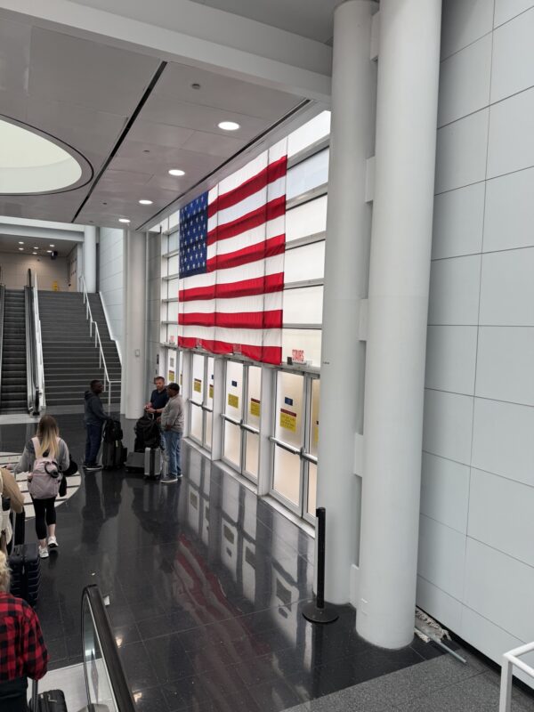 people standing in a hallway with a flag on the wall